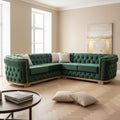 Green velvet sectional sofa with tufted backrests on a dark floor, branded 'Velora living'.