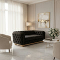 Black tufted sofa on a black marble floor with 'Velora living' text above.